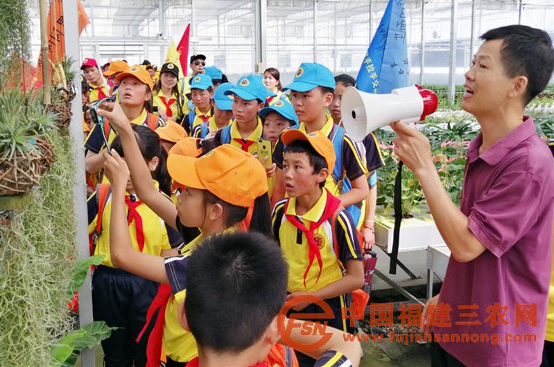 10月1日，福建省农业科学院花卉专家林兵（右一）向闽藏少年儿童介绍会吃蚊子的猪笼草种植.jpg